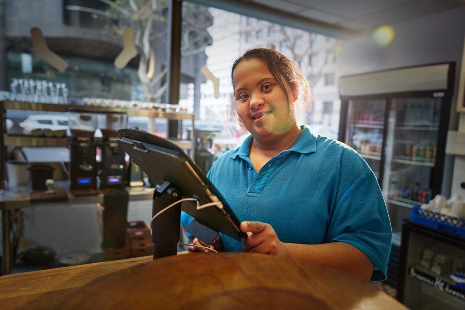 Portrait confident young woman with Down Syndrome working in cafe