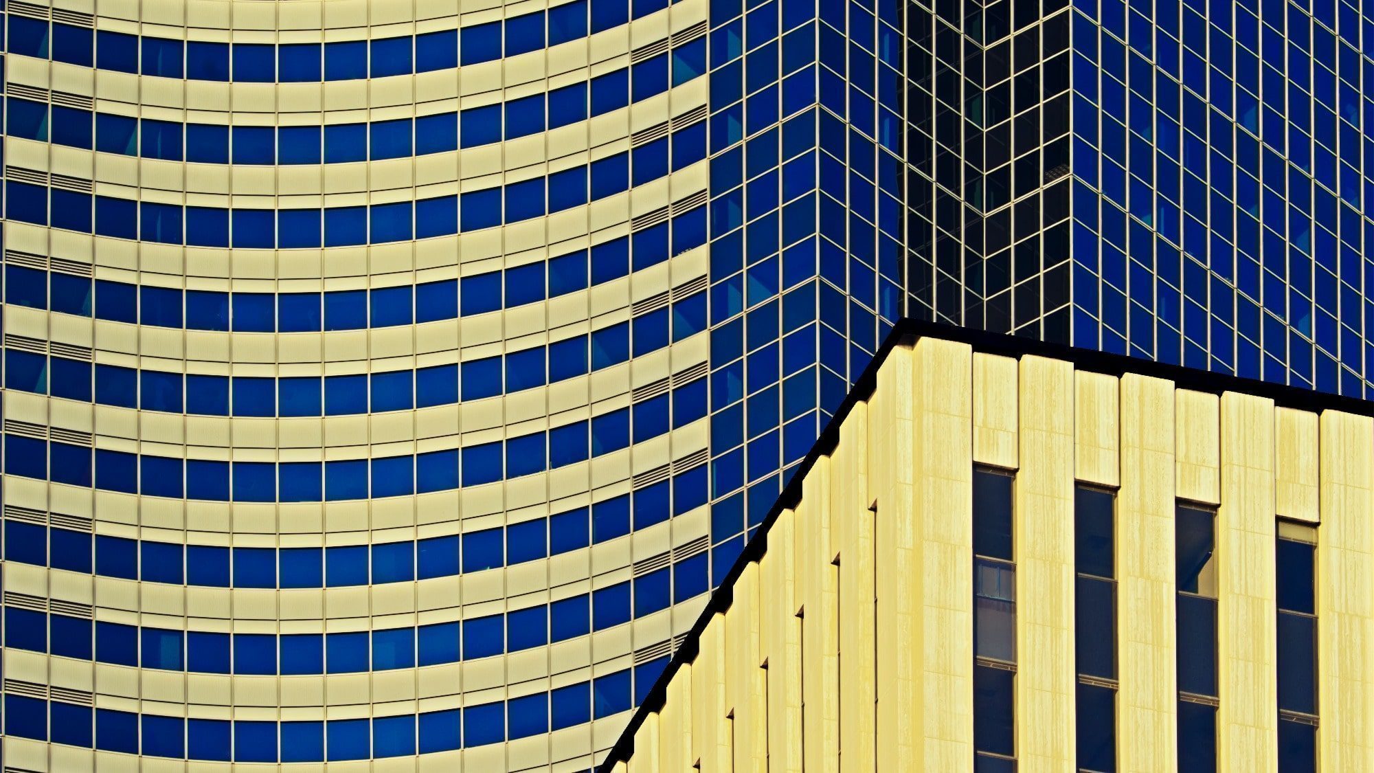 A color photograph of a modern commercial skyscraper with one of downtown Seattle's elder commercial structures in the foreground. 