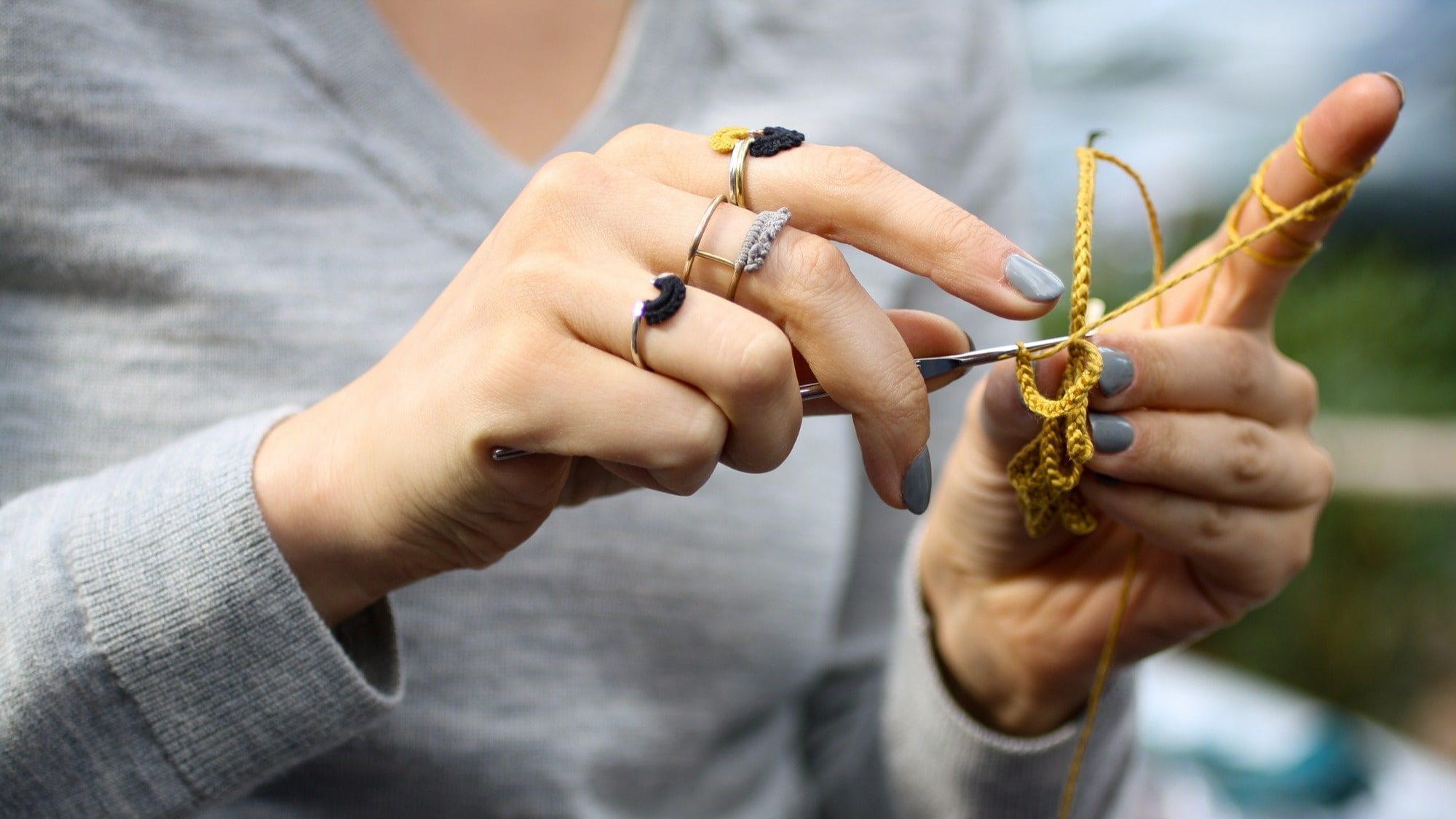 The artist crocheting lace onto other materials to make jewelry
